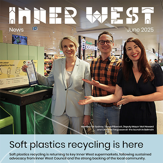 Three people smiling for a photograph alongside a soft plastic recycling bin in a supermarket. Over the photo is the text 